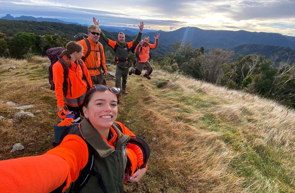 Five works in hi viz take a selfie on top of a hill