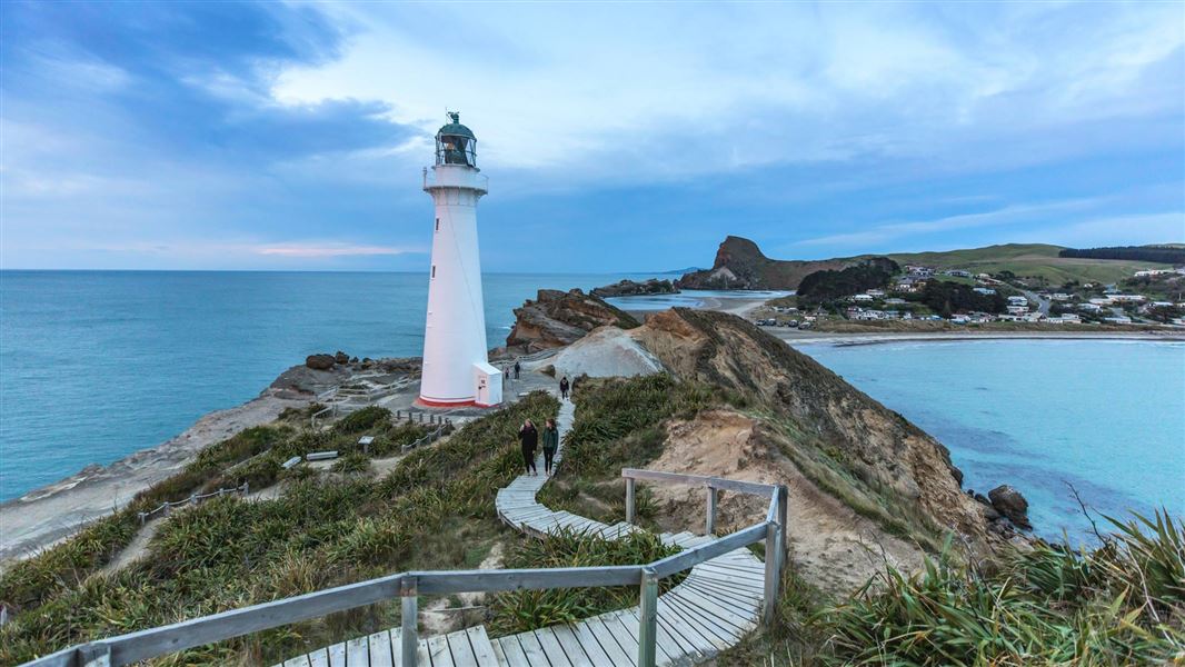 Lighthouse on point with board walk and lagoon in the background. 