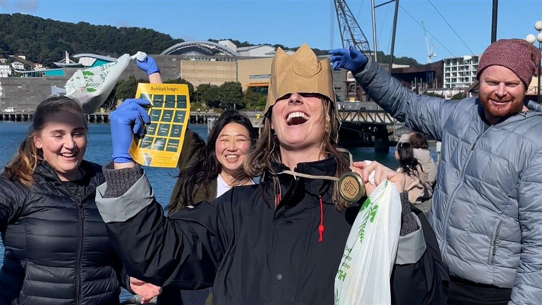 Rubbish bingo winner crowned with crown and medal with co-worker behind on the Wellington waterfront. 