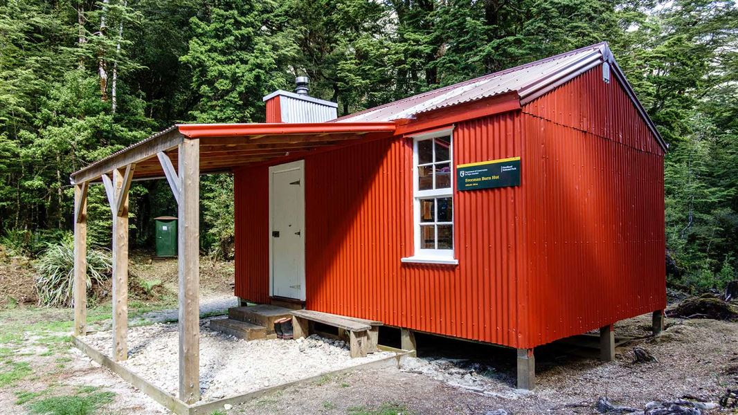 Red DOC hut with verandah.