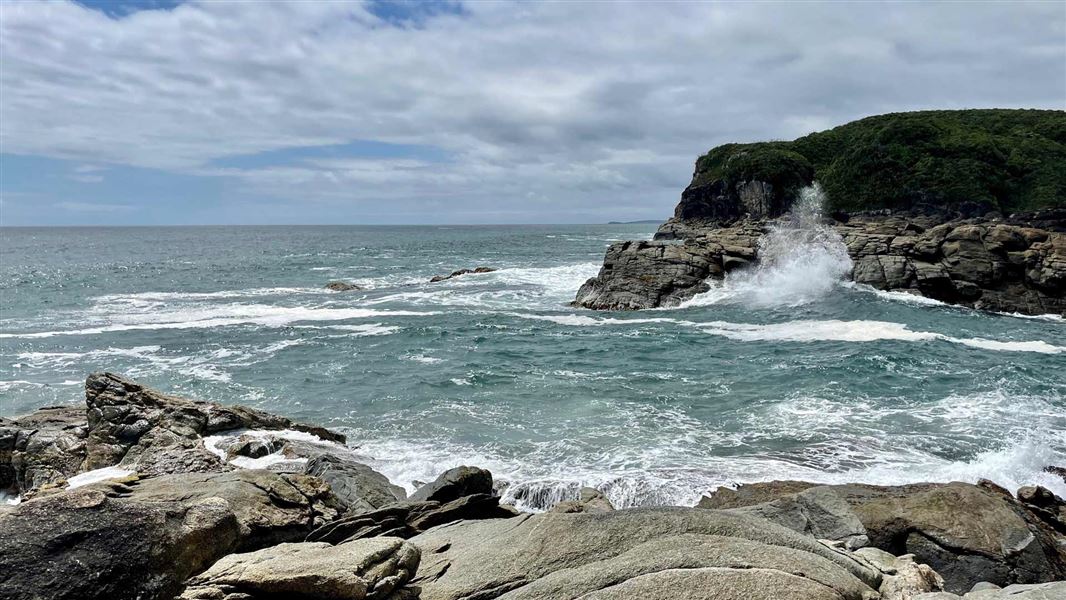 Surf splashing against the rocky point. 