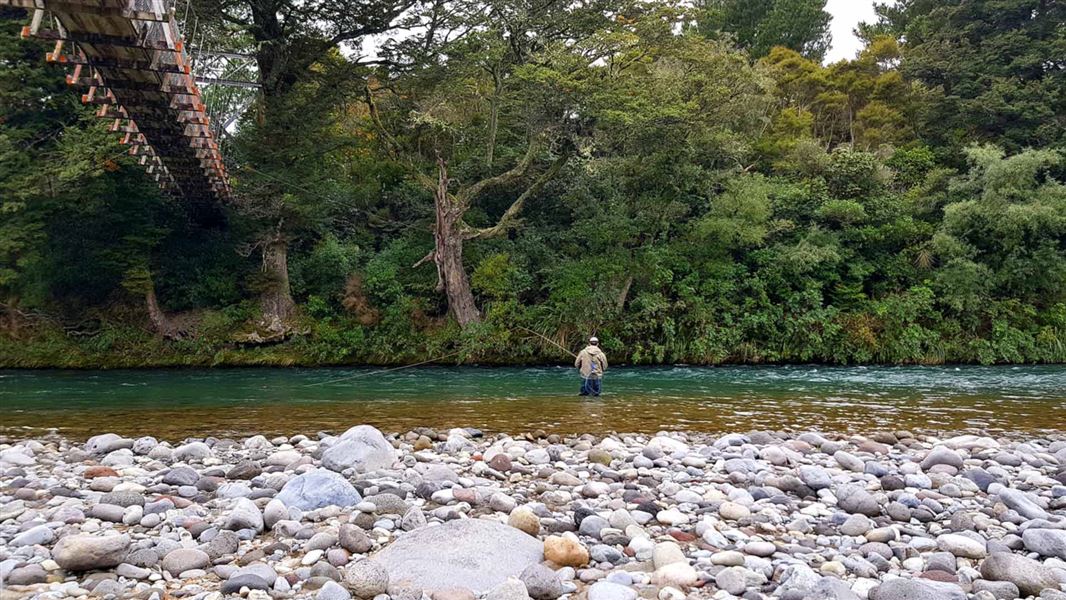 James Fuller fly fishing under bridge. 