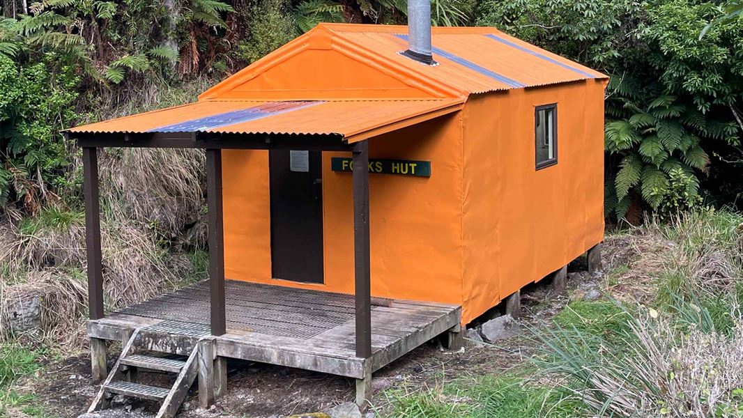 Orange hut with balcony and chimney. 