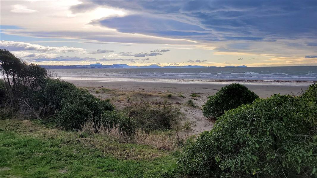 Looking out at a leaden sea from a grassy sand dune.