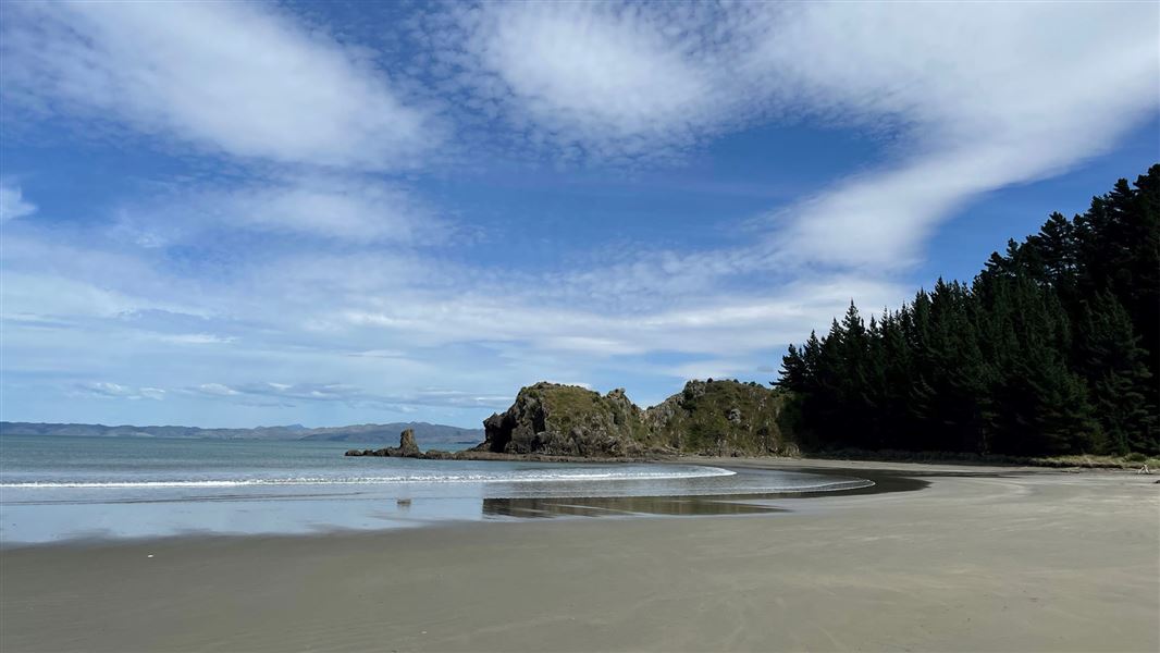 Sandy beach and low surf on a sunny day. 