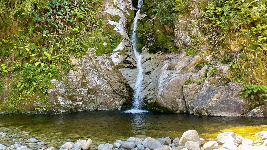 Waterfall flowing through mossy covered rocks. 