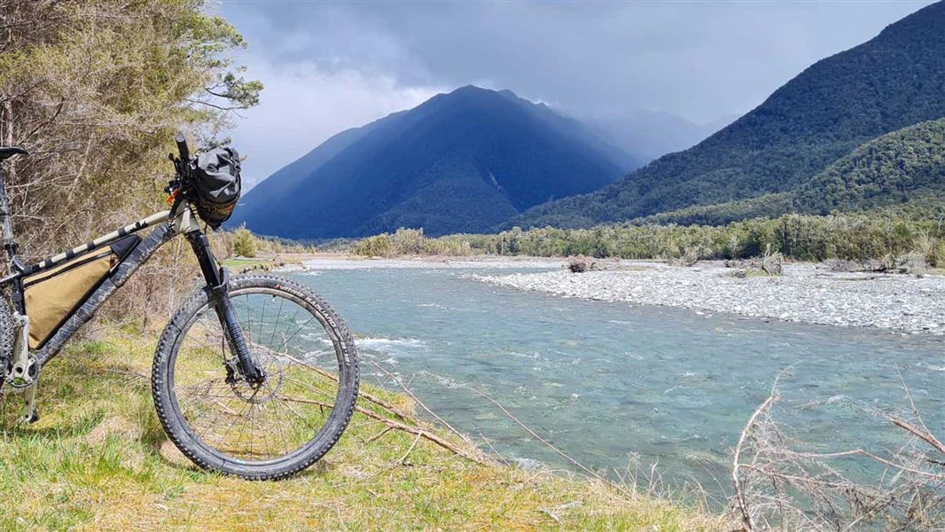 Bike with river and mountains in the background. 