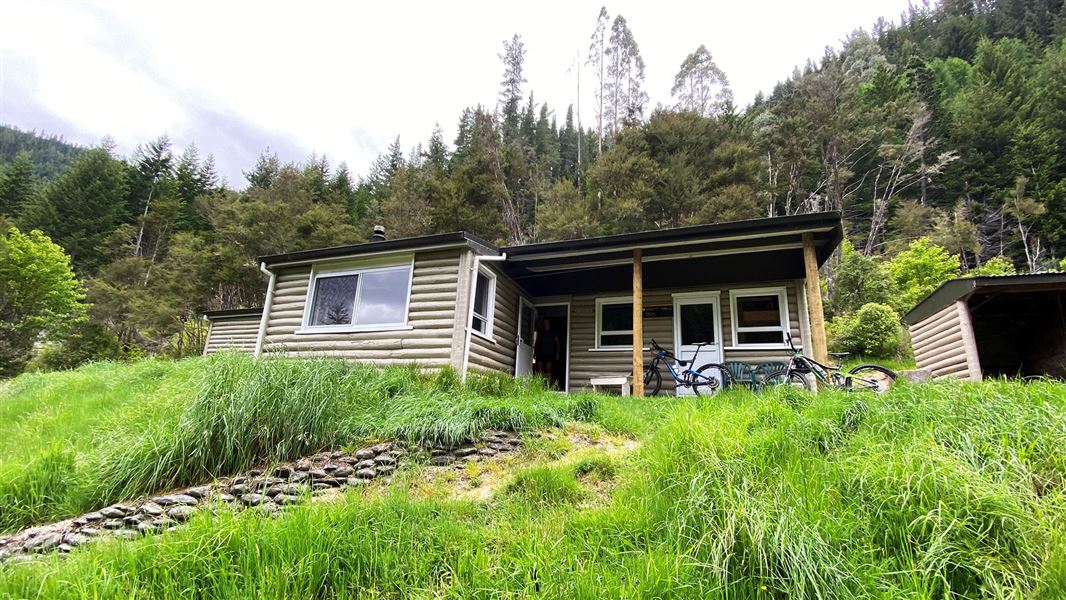 Single story wooden building in grassy area.