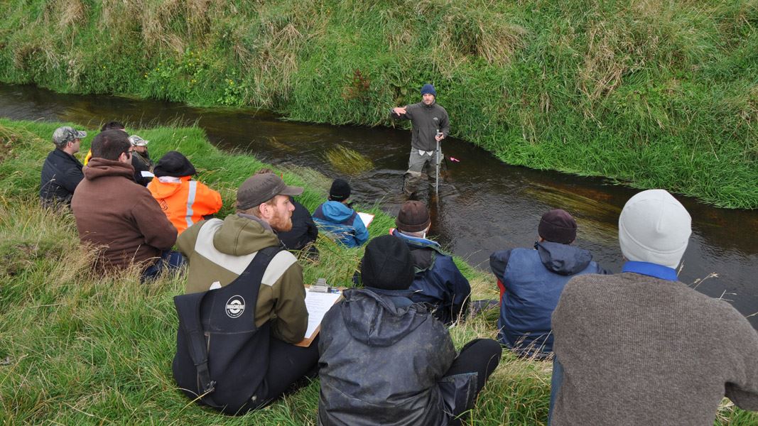 People being briefed by stream. 