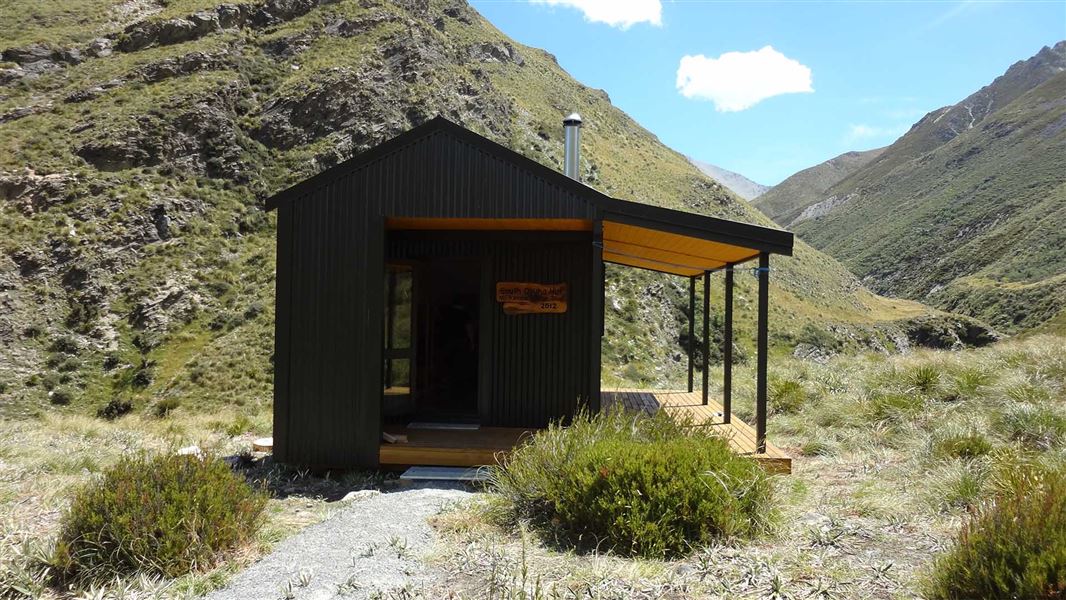 A small hut sits in a deep valley.