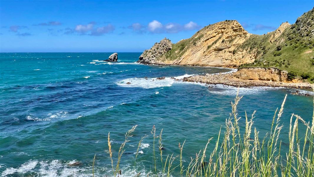 View out towards a rocky and steep peninsula and coast line. 