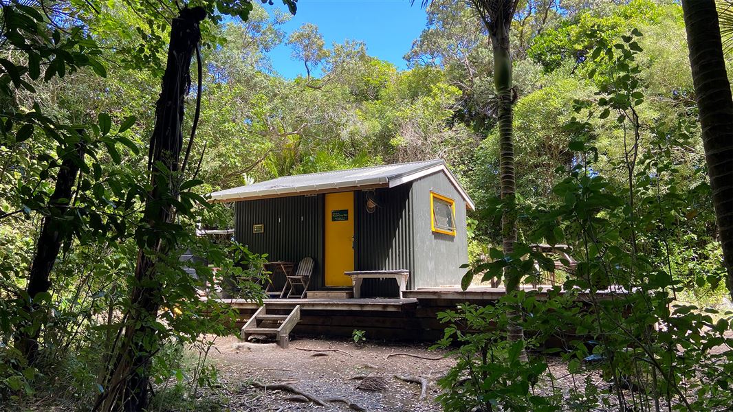 Small building surrounded by trees.