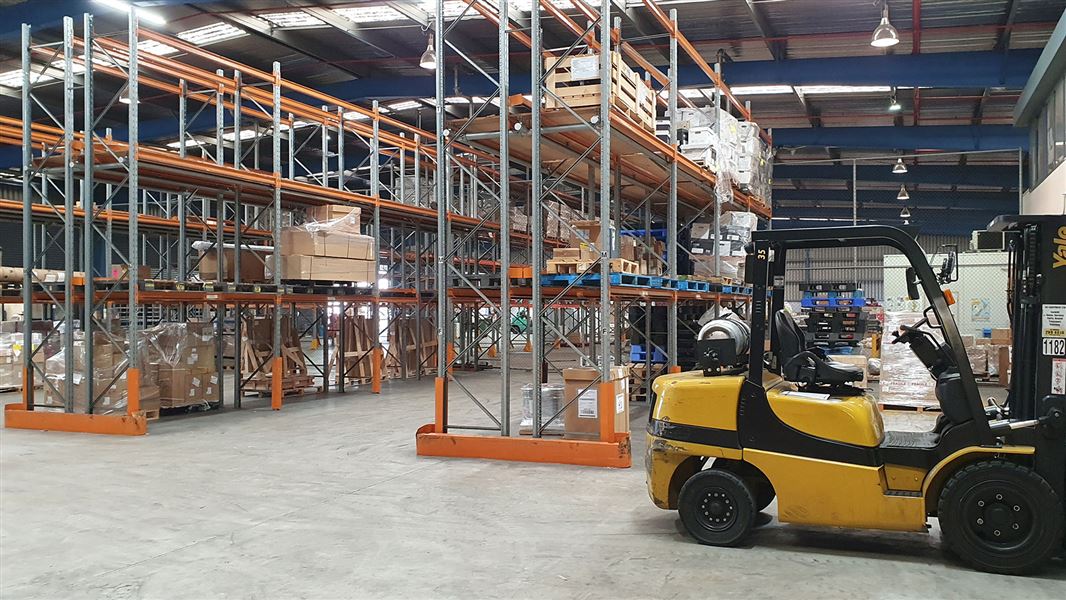 Yellow forklift and industrial shelves.