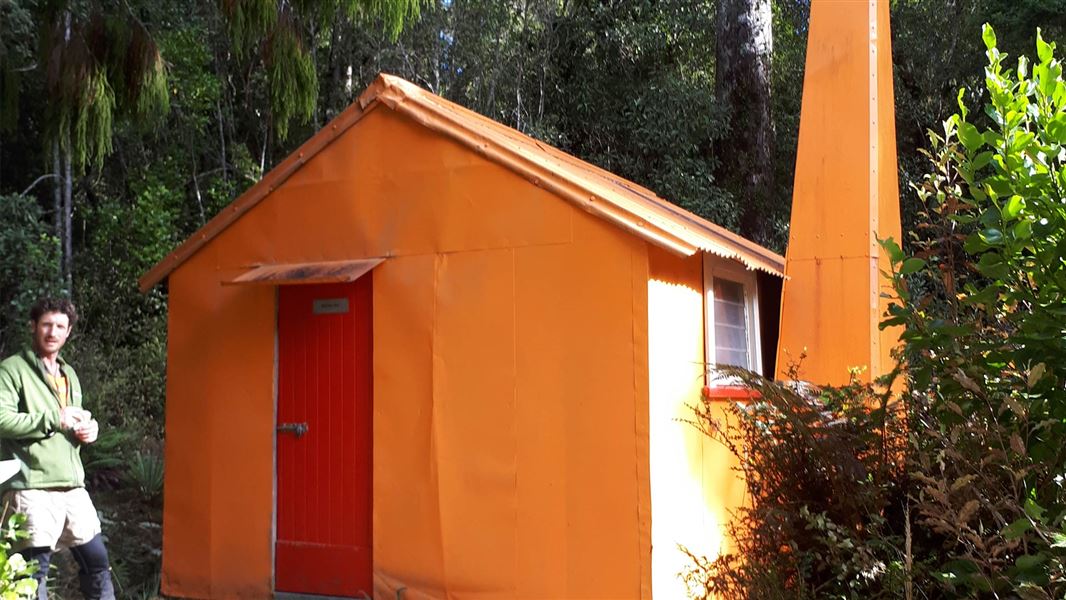 Orange tin hut in bush.