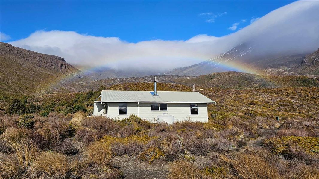 Mangatepopo Hut with a rainbow behind. 