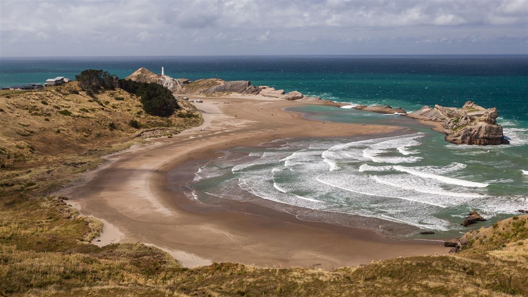 Beach with lighthouse in distance. 