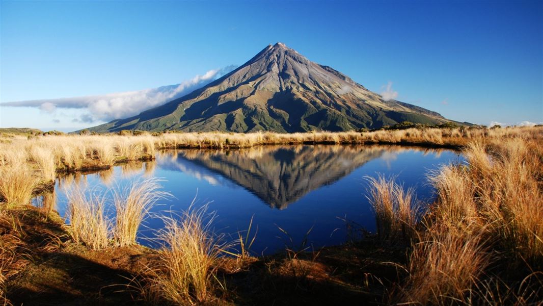 Mt Taranaki reflected in the lake water - a rare phenomenon in a windswept region.