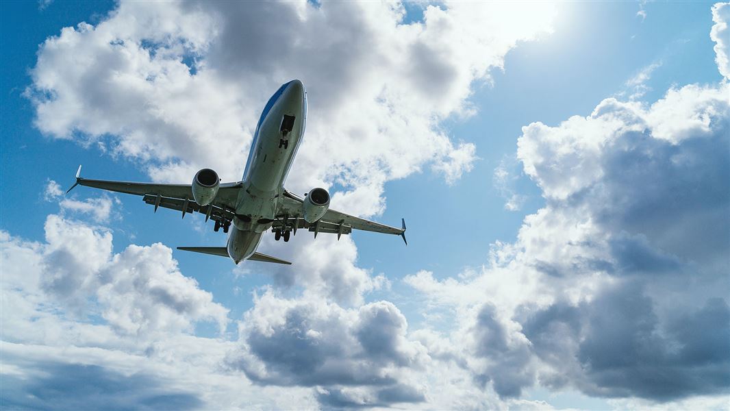 Plane in blue sky with clouds.