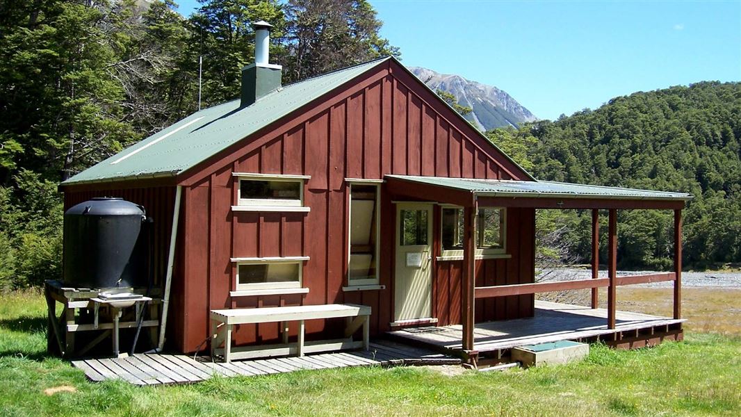 A red hut on a flat plain.