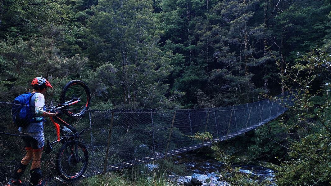 Swing bridge with person wheeling bike.