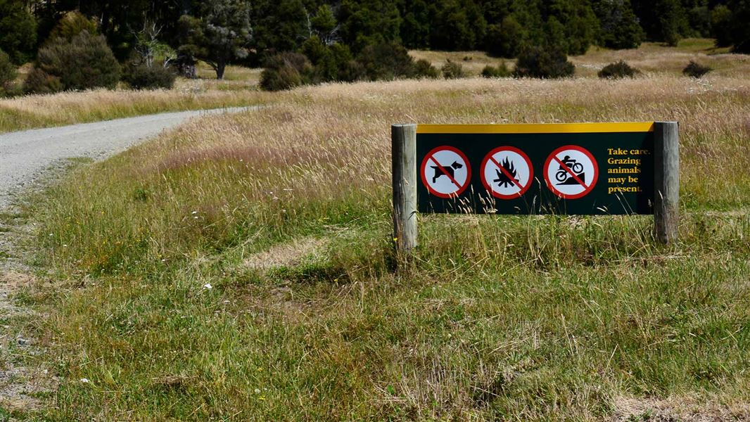 DOC sign showing no dogs, fires or mountain biking. 