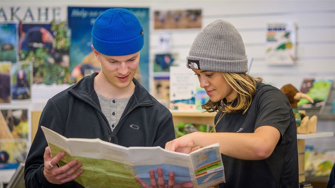 Two people reading a map in a visitor centre. 