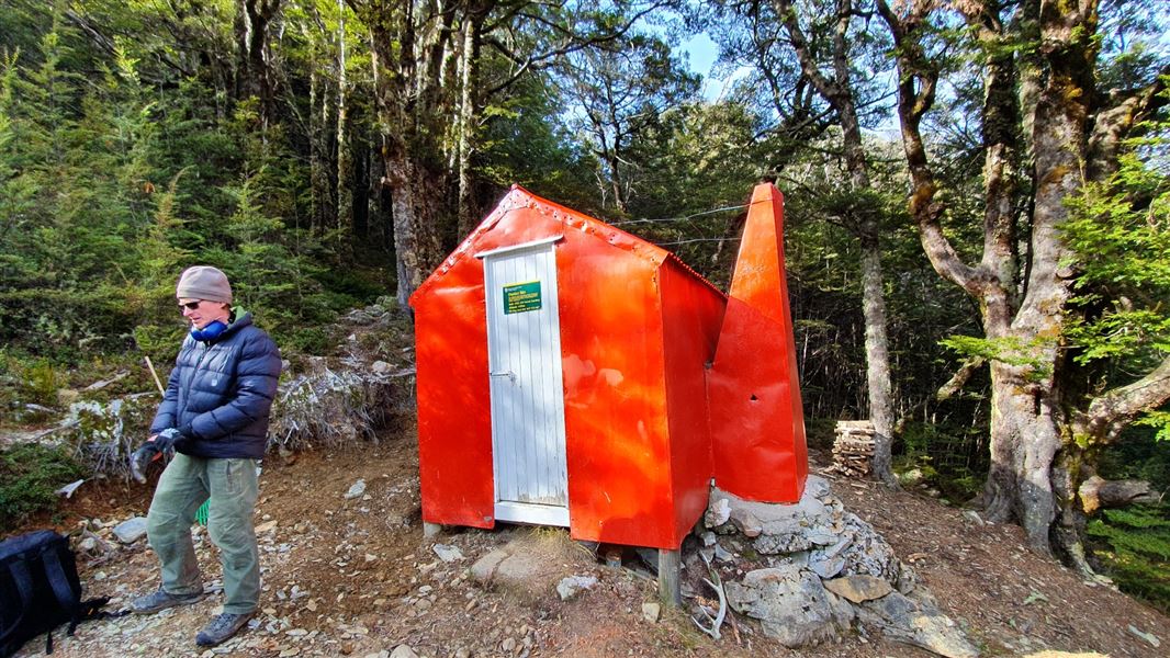 Bright orange hut surrounded by trees