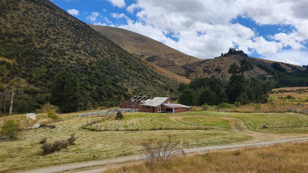 Historic woolshed surrounded by hills