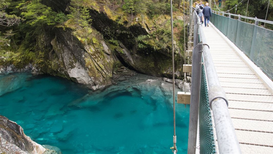 A picture showing a bridge with clear, deep blue water below.