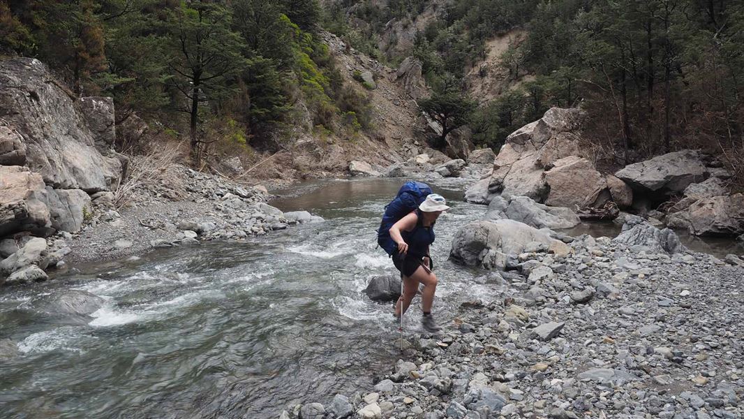 Tramper crossing stream.