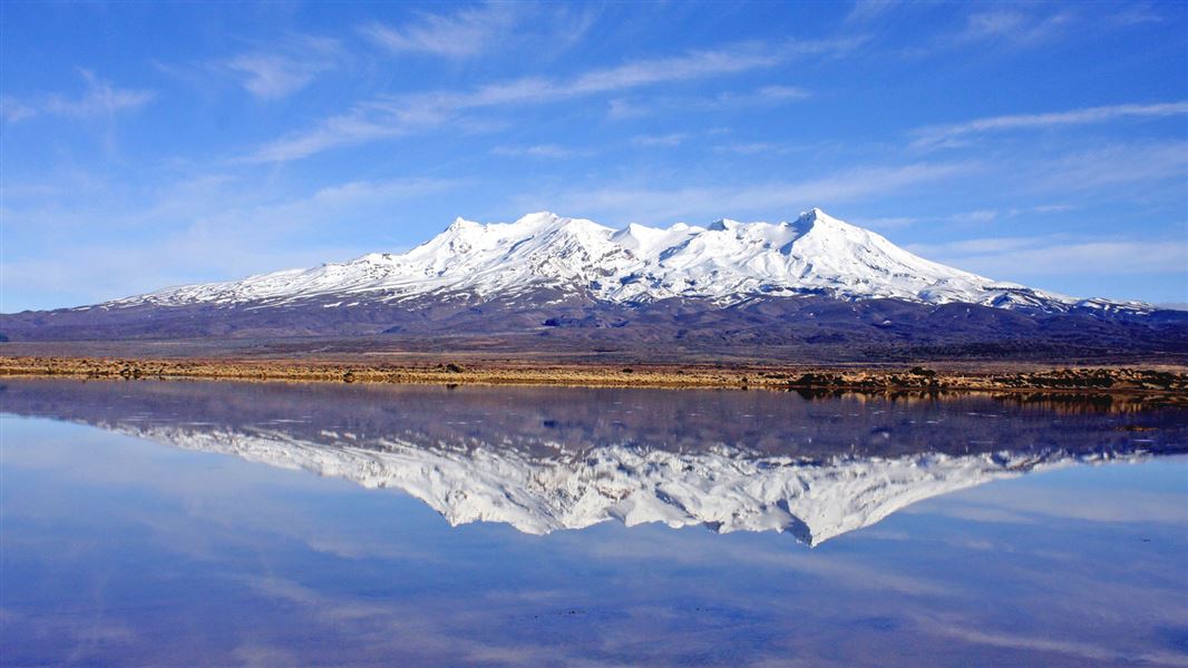 Majestic Mount Ruapehu reflected in the water as viewed from the Desert Road.