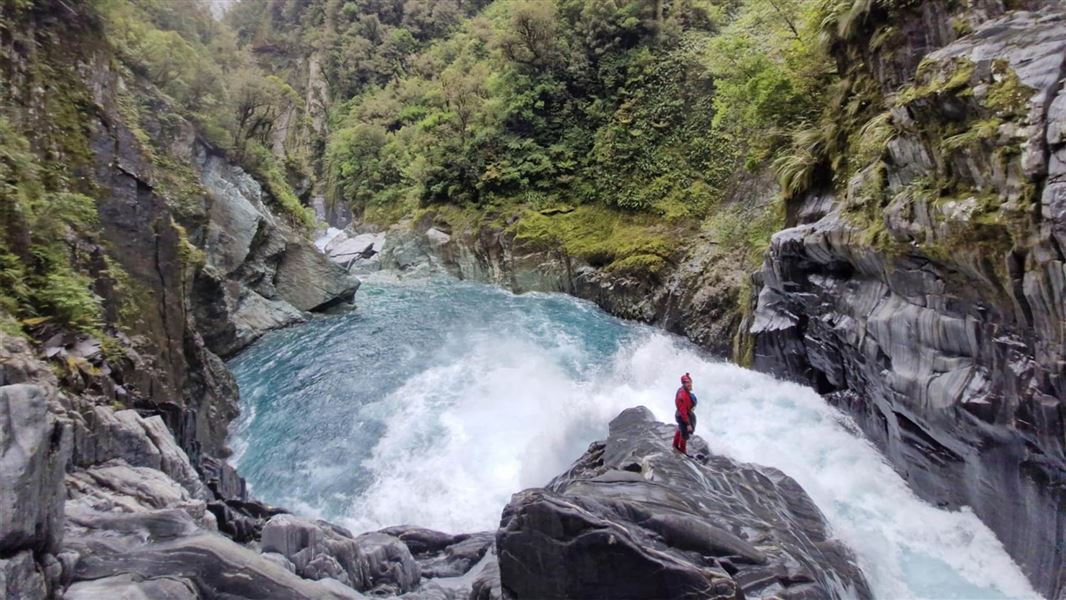 A kayaker at the top of Toaroha Falls at the top of Toaroha canyon