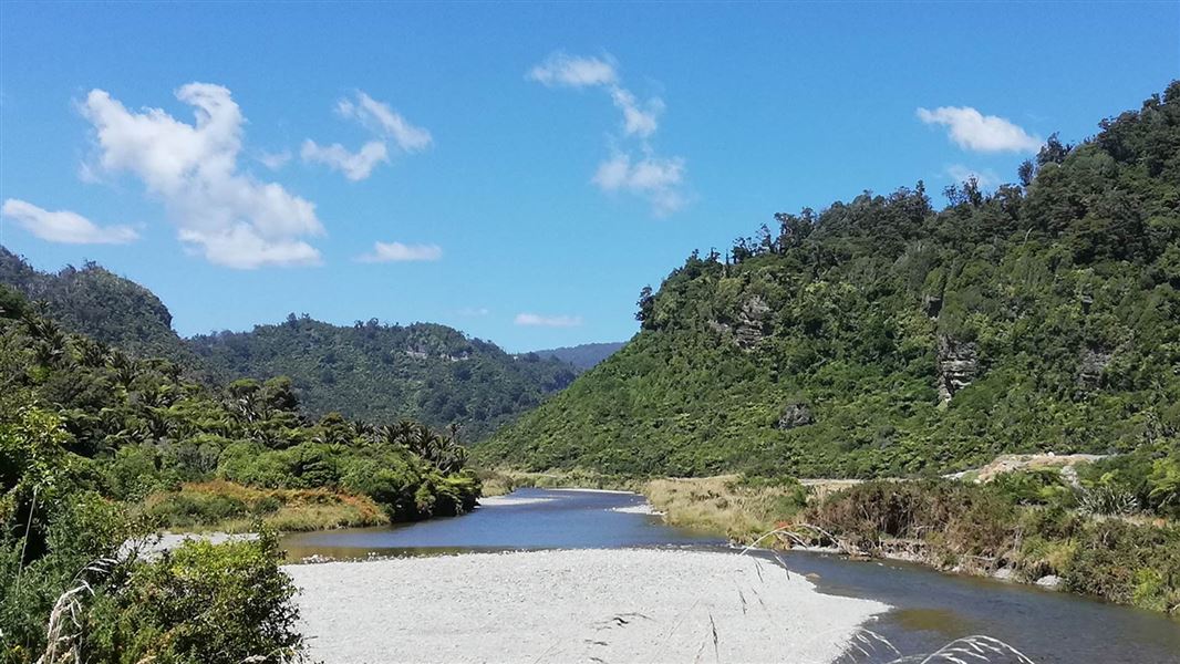 A river winds through steep forested hills.