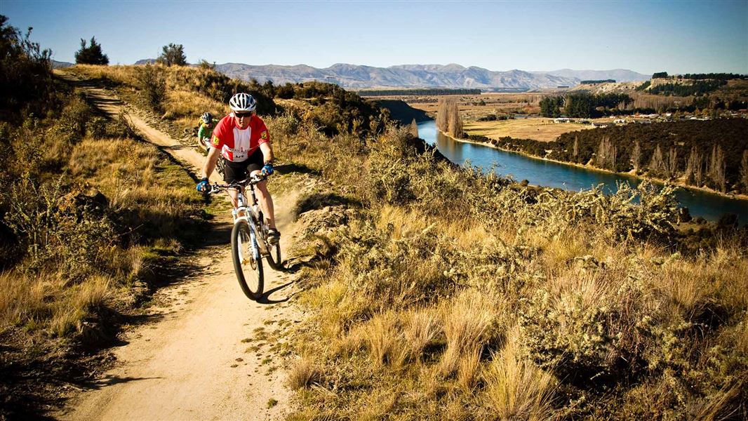 Two mountain bikers go down a trail.